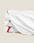 Marrakesh Piquet blanket cover stack in white/white, white/sterling and white/scarlet
