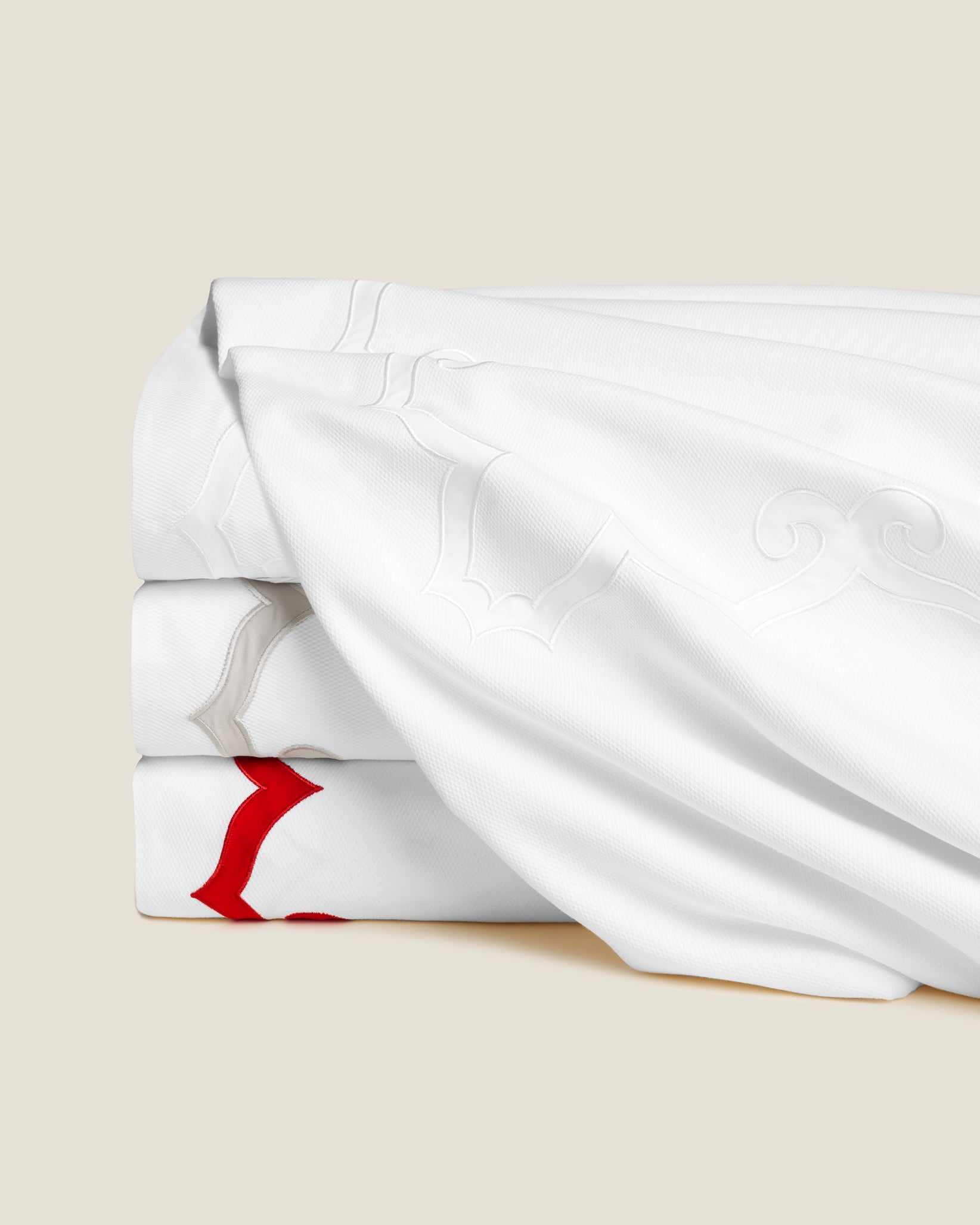 Marrakesh Piquet blanket cover stack in white/white, white/sterling and white/scarlet